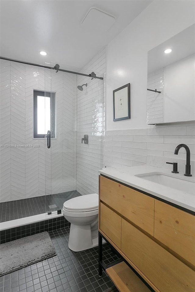 bathroom featuring walk in shower, vanity, tile walls, tile patterned flooring, and toilet