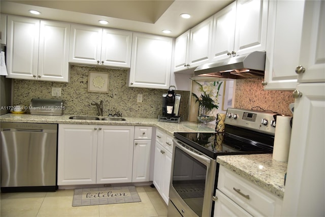 kitchen featuring appliances with stainless steel finishes, sink, light tile patterned floors, and white cabinets