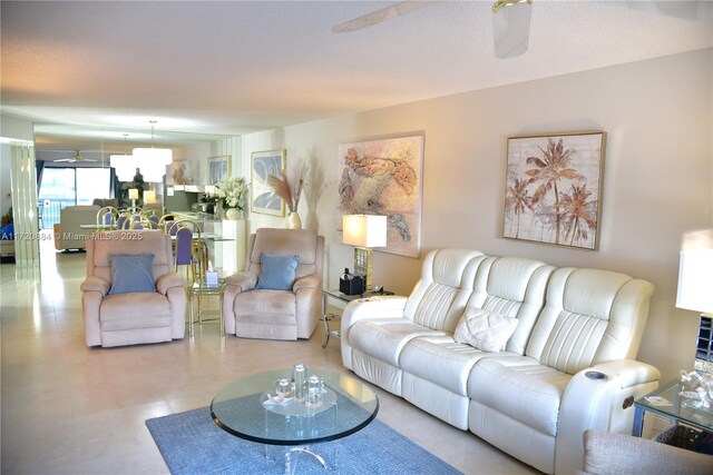 living room with a textured ceiling and ceiling fan