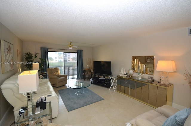 living room featuring ceiling fan and a textured ceiling