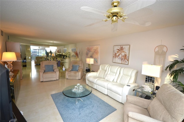 living room with ceiling fan and a textured ceiling