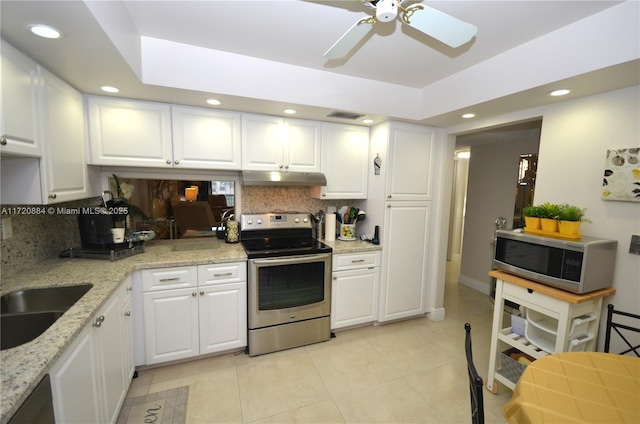 kitchen featuring light stone counters, stainless steel appliances, and white cabinets