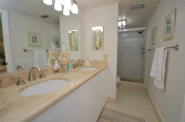 bathroom with tile patterned floors, toilet, a shower with shower door, and vanity