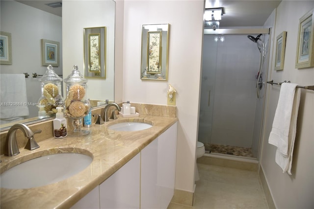 bathroom with tile patterned floors, vanity, toilet, and a shower with door