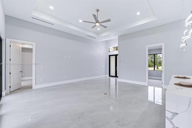 interior space with a tray ceiling and ceiling fan