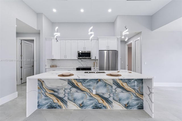 kitchen featuring decorative backsplash, appliances with stainless steel finishes, light stone counters, sink, and white cabinets