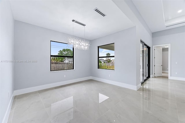 spare room with a notable chandelier