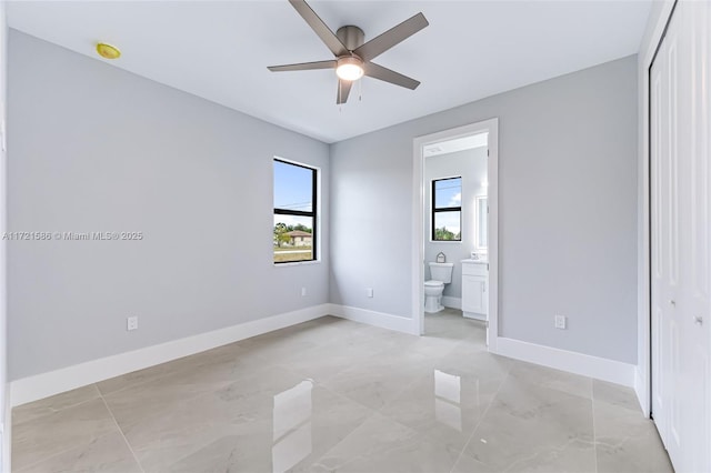 unfurnished bedroom featuring a closet, ensuite bath, and ceiling fan