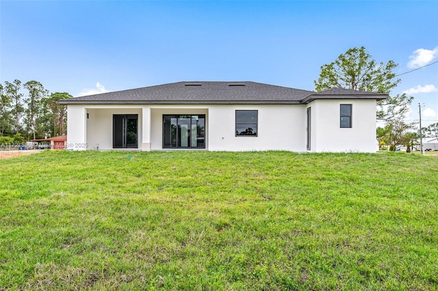 rear view of house featuring a lawn