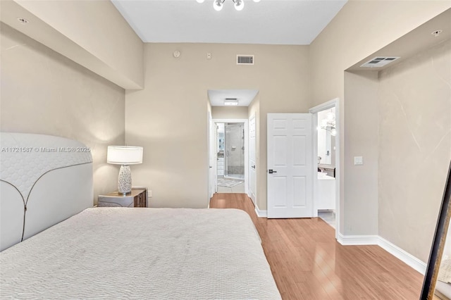 bedroom featuring ensuite bathroom and light hardwood / wood-style flooring