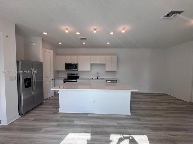 kitchen featuring white cabinetry, a center island with sink, stainless steel appliances, and sink