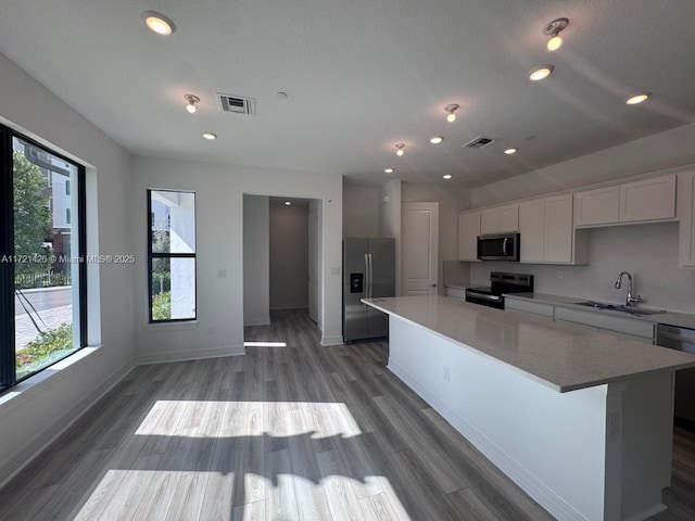 kitchen featuring sink, a center island, a healthy amount of sunlight, and appliances with stainless steel finishes