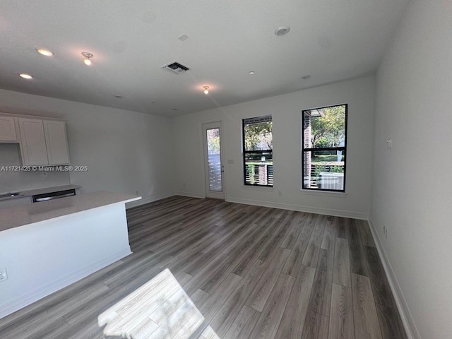 interior space featuring white cabinets, hardwood / wood-style flooring, and tasteful backsplash