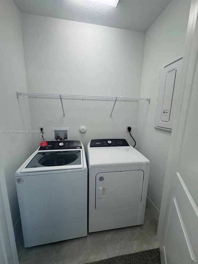 washroom with a textured ceiling, separate washer and dryer, and tile patterned floors