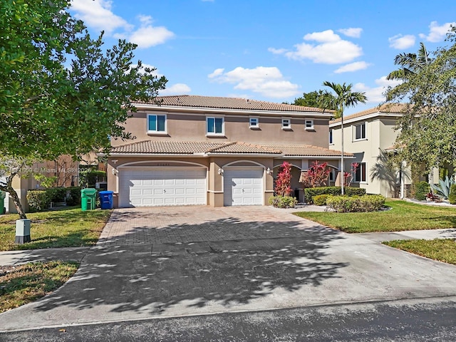 mediterranean / spanish-style home with a garage and a front lawn