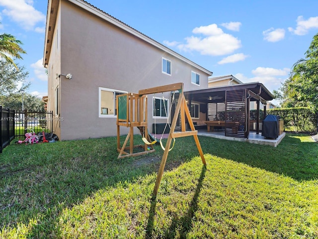 rear view of house featuring a lawn, a playground, and a patio