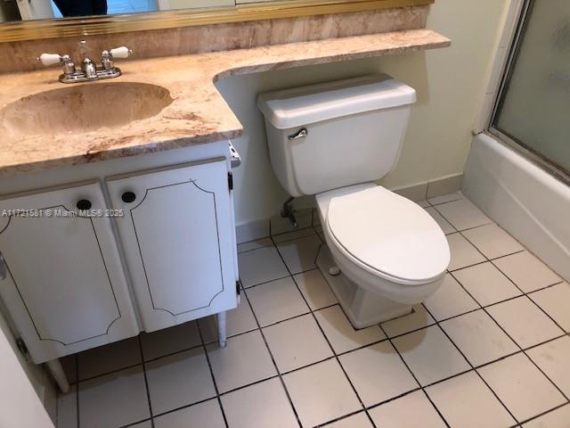 full bathroom featuring tile patterned floors, vanity, toilet, and combined bath / shower with glass door