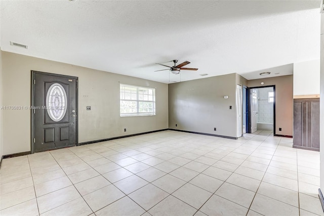 tiled foyer featuring a textured ceiling and ceiling fan