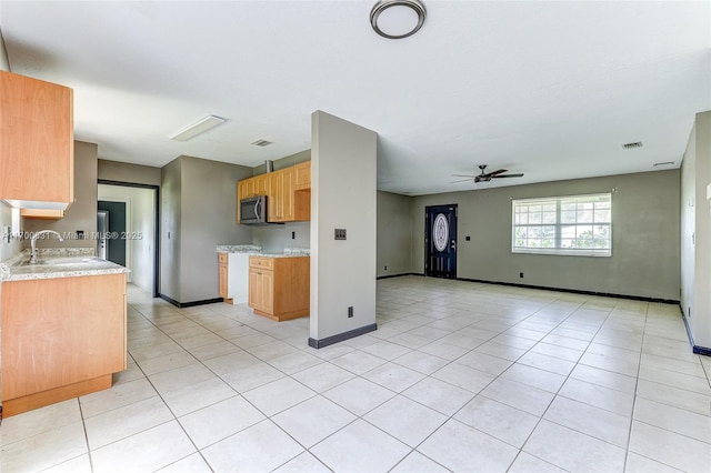 kitchen featuring light tile patterned floors, ceiling fan, and sink