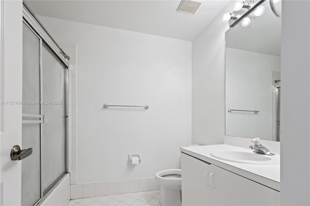 full bathroom featuring tile patterned floors, vanity, combined bath / shower with glass door, and toilet