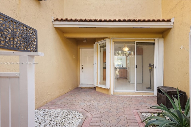 view of exterior entry with a patio area