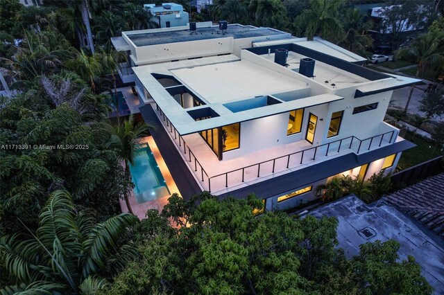 pool at dusk featuring a jacuzzi, ceiling fan, and a patio area