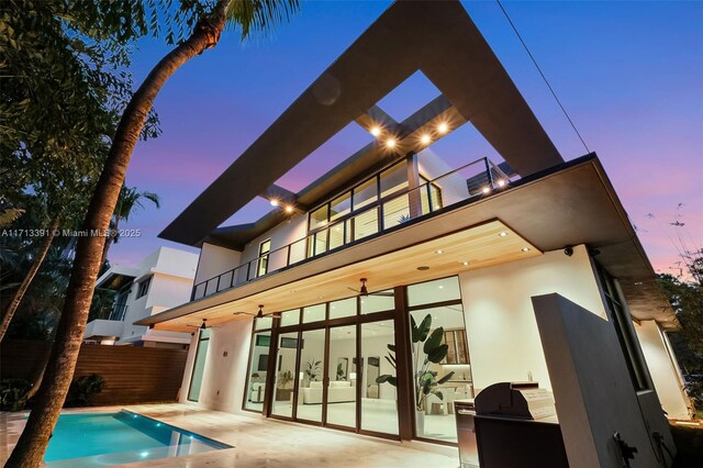 contemporary home featuring a front yard and a balcony