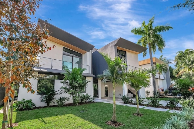 contemporary home with a balcony and a front yard