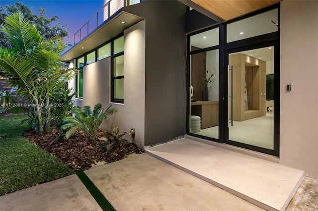 doorway to property with a patio and stucco siding