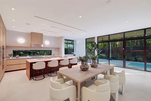 dining space with a wall of windows and recessed lighting