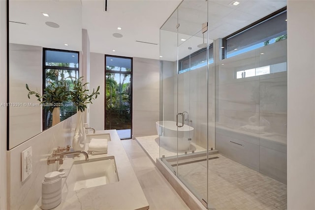 bathroom with a healthy amount of sunlight, a stall shower, a sink, and tile patterned floors