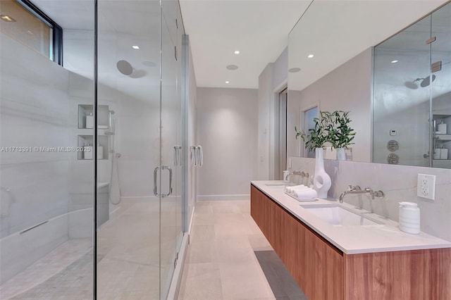 bathroom with double vanity, backsplash, a sink, and a shower stall