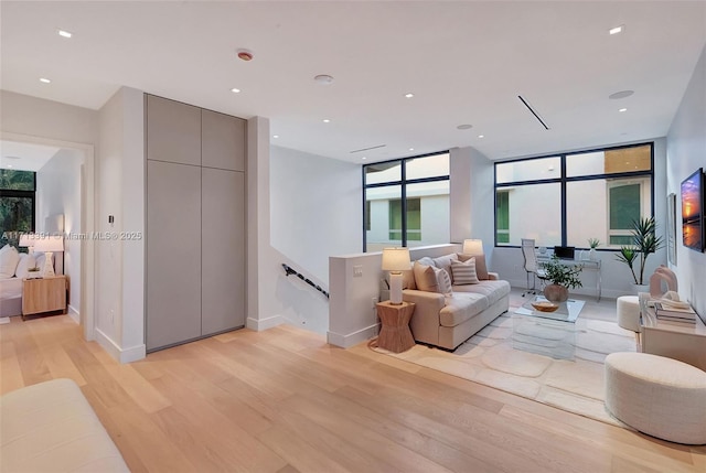 living room featuring light wood-style floors, recessed lighting, and baseboards