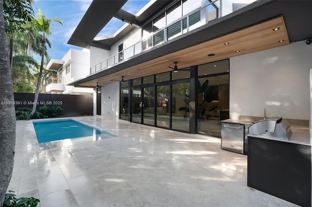 view of pool with a patio, an outdoor kitchen, fence, and a fenced in pool