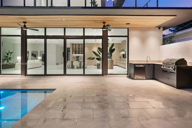 view of patio with ceiling fan, area for grilling, a sink, exterior kitchen, and an outdoor pool