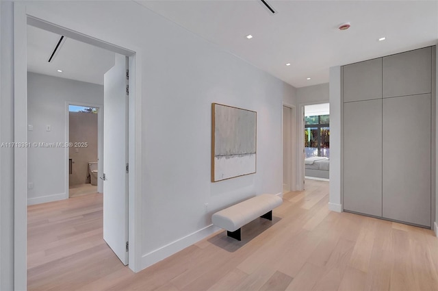 hall with light wood finished floors, baseboards, and recessed lighting