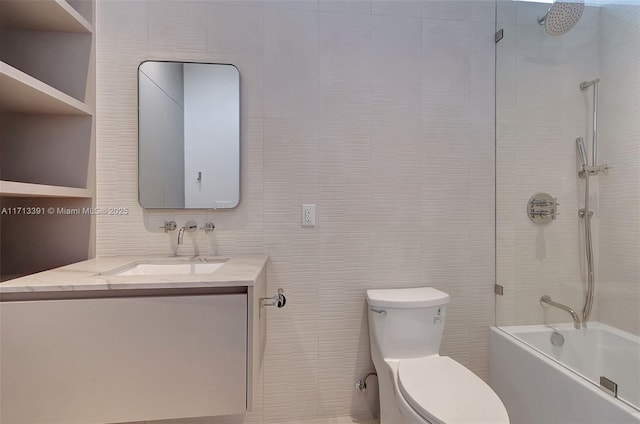 bathroom with shower / bathing tub combination, vanity, toilet, and tile walls