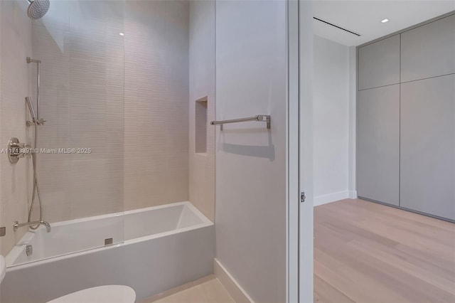 full bath featuring tub / shower combination, wood finished floors, and toilet