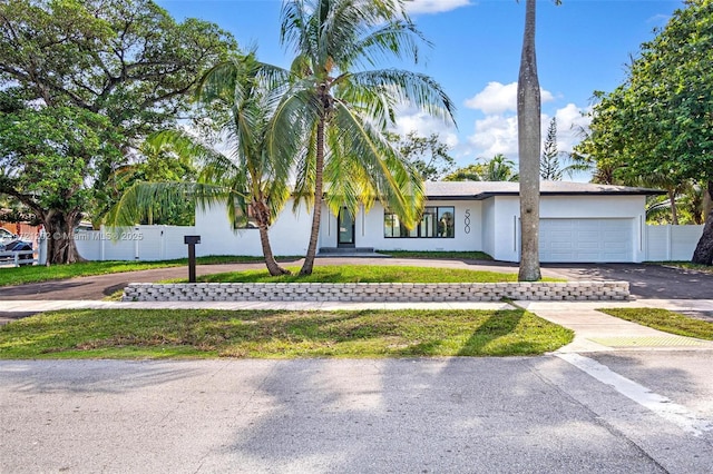 view of front of house with a garage and a front lawn