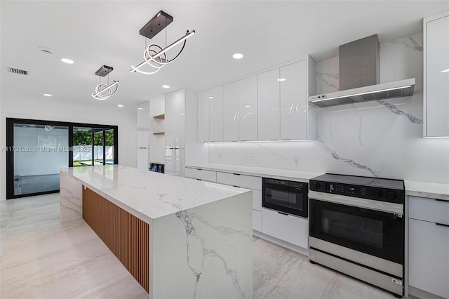 kitchen featuring white cabinetry, electric range, decorative light fixtures, and wall chimney range hood