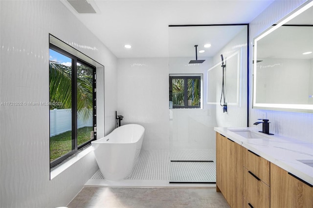 bathroom featuring vanity, a bath, and concrete floors