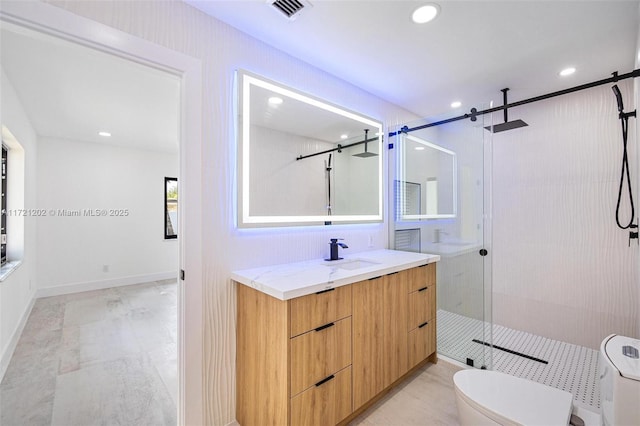 bathroom featuring vanity, a shower with shower door, and toilet