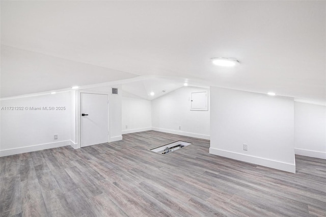 additional living space featuring hardwood / wood-style flooring and vaulted ceiling