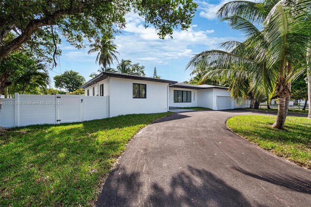 ranch-style home with a garage and a front lawn