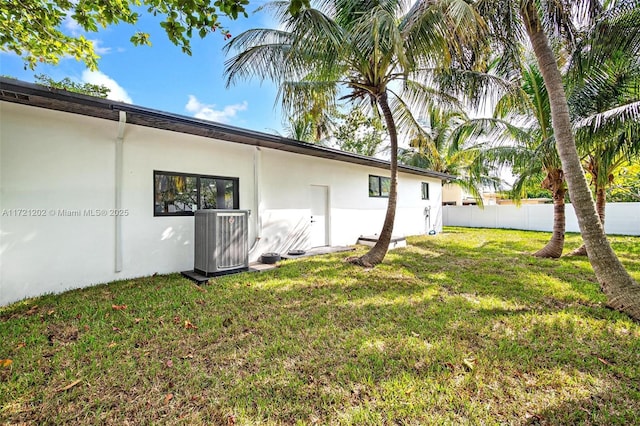 exterior space featuring central AC unit and a lawn