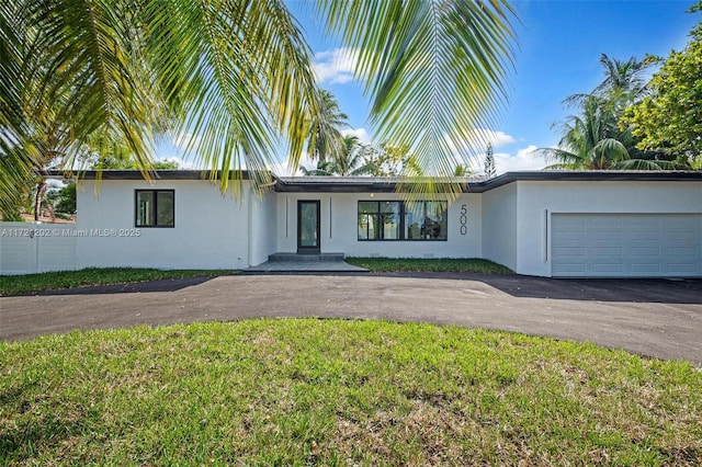 ranch-style house featuring a garage and a front lawn