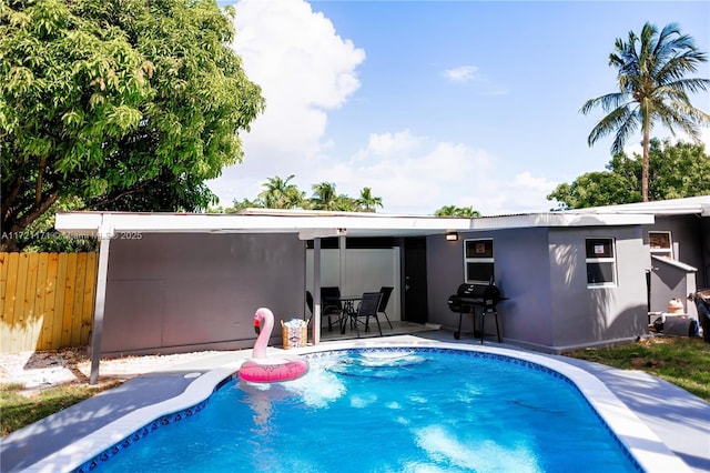 back of house with a fenced in pool and a patio