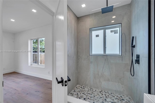 bathroom featuring hardwood / wood-style floors and tiled shower