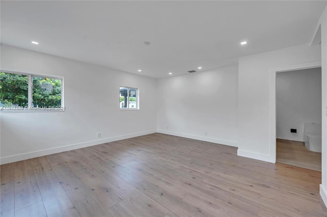 empty room with plenty of natural light and light hardwood / wood-style floors