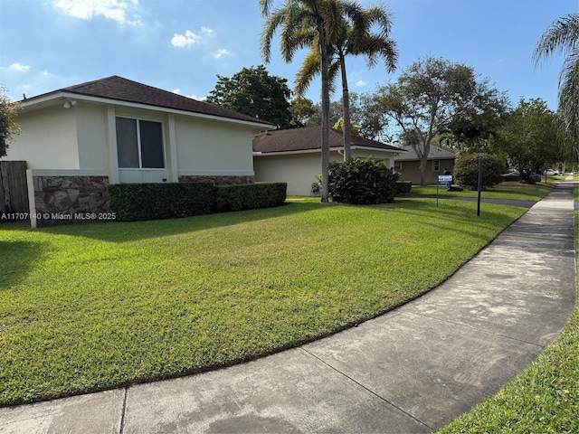 view of side of home with a yard